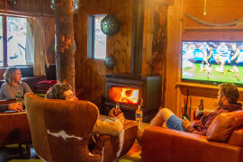 relaxing by the fire and watching footy at Bruny Island Lodge